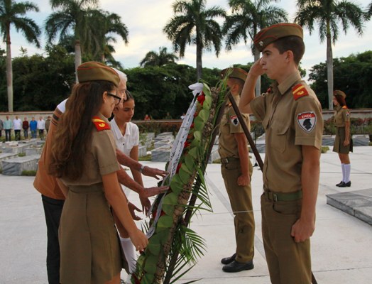Estudiantes y un combatiente del Frente Norte durante el arreglo de las cintas de la ofrenda floral a nombre del pueblo de Cuba, para los combatientes del Frente Norte. Foto: Oscar Alfonso Sosa.