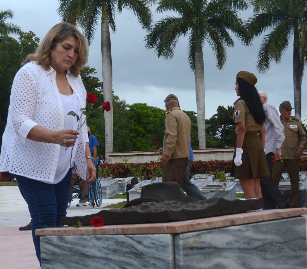 Deivy Pérez Martín, miembro del Comité Central del Partido Comunista de Cuba y su primera secretaria en el territorio, coloca una flor en el nicho de Camilo.